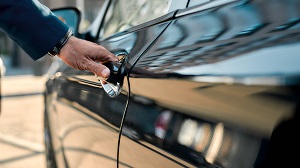 man with hand on handle of car door