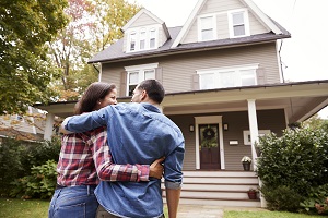 couple standing in front of their home